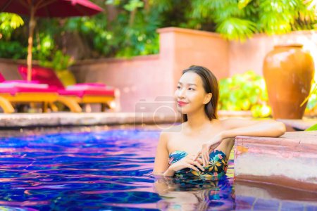 Téléchargez les photos : Portrait belle jeune femme asiatique relax sourire profiter des loisirs autour de la piscine en hôtel station balnéaire en vacances - en image libre de droit
