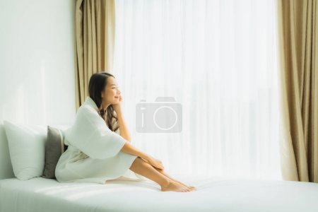 Photo for Young asian woman happy smile relax on bed in bedroom interior - Royalty Free Image