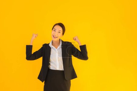 Téléchargez les photos : Beau portrait jeune entreprise asiatique femme heureux sourire dans beaucoup action sur jaune isolé fond - en image libre de droit