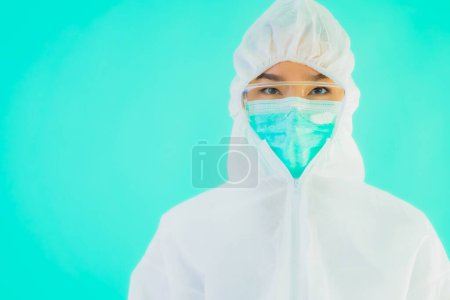 Téléchargez les photos : Portrait belle jeune asiatique médecin femme porter ppe ou équipement de protection individuelle pour protéger contre le coronavirus ou covid19 sur fond bleu isolé - en image libre de droit