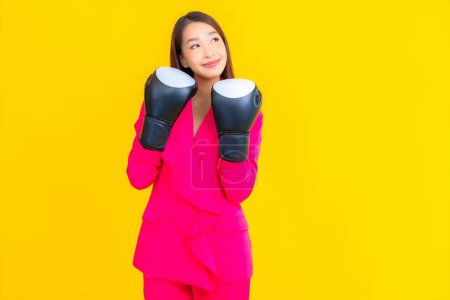 Téléchargez les photos : Portrait belle jeune femme asiatique avec boxe sur fond jaune isolé - en image libre de droit