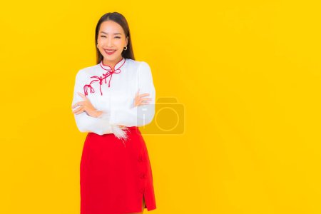 Téléchargez les photos : Portrait belle jeune femme asiatique sourire en action sur fond jaune - en image libre de droit
