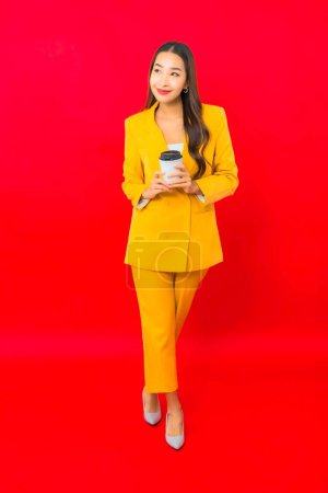 Photo for Portrait beautiful young business asian woman with coffee cup on red background - Royalty Free Image