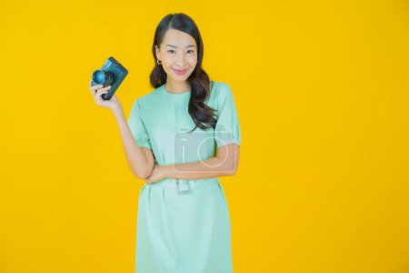 Téléchargez les photos : Portrait belle jeune femme asiatique utiliser caméra sur fond de couleur - en image libre de droit