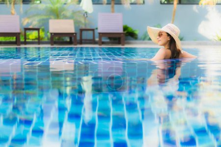 Foto de Retrato hermosa joven mujer asiática relajarse alrededor de la piscina en el complejo hotelero para el ocio en vacaciones - Imagen libre de derechos