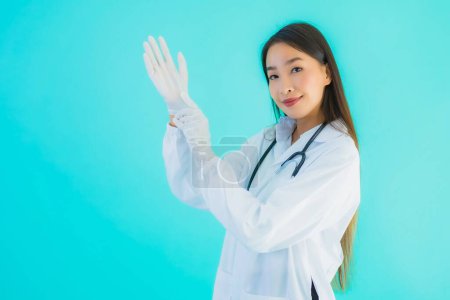 Photo for Portrait beautiful young asian doctor with glove for use in clinic or hospital on blue isolated background - Royalty Free Image