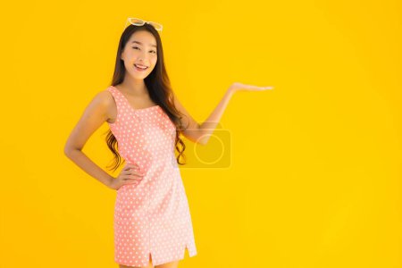 Foto de Retrato hermosa joven asiática mujer sonrisa feliz en amarillo aislado fondo - Imagen libre de derechos