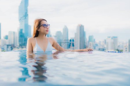 Photo for Portrait beautiful young asian woman relax happy smile leisure around outdoor swimming pool with cityscape - Royalty Free Image