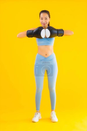 Foto de Retrato hermosa joven mujer asiática usar ropa deportiva con el boxeo en amarillo aislado fondo - Imagen libre de derechos
