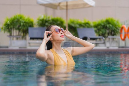 Foto de Retrato hermosa joven mujer asiática relajarse ocio alrededor de la piscina en el complejo hotelero - Imagen libre de derechos