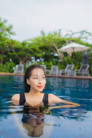 Téléchargez les photos : Portrait belle jeune femme asiatique loisirs relax sourire autour de la piscine extérieure pour les vacances - en image libre de droit