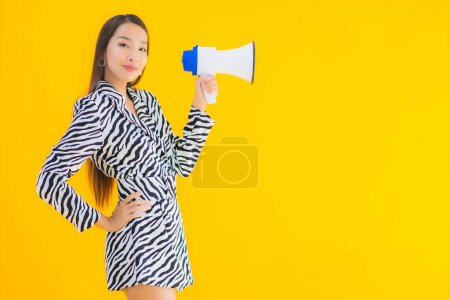 Photo for Portrait beautiful young asian woman smile happy with megaphone on yellow isolated background - Royalty Free Image