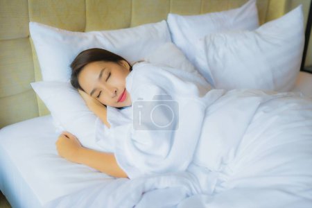 Téléchargez les photos : Portrait belle jeune femme asiatique dormir sur le lit avec oreiller et couverture dans la chambre à coucher intérieur - en image libre de droit
