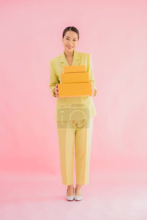 Téléchargez les photos : Portrait belle jeune femme asiatique avec boîte de colis sur fond de couleur - en image libre de droit