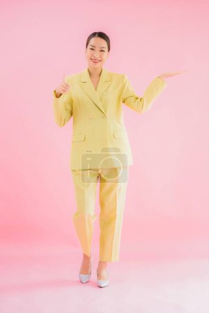 Téléchargez les photos : Portrait belle jeune femme d'affaires asiatique sourire en action sur fond de couleur rose - en image libre de droit