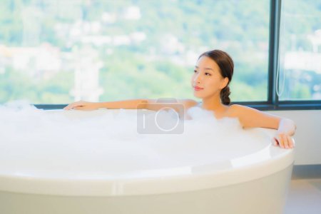 Téléchargez les photos : Portrait belle jeune femme asiatique se détendre loisirs profiter dans la baignoire à la salle de bain et WC intérieur - en image libre de droit