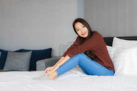 Foto de Retrato hermosa joven mujer asiática relajarse en la cama en el interior del dormitorio - Imagen libre de derechos