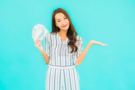 Photo for Portrait beautiful young asian woman with a lot of cash and money on blue background - Royalty Free Image