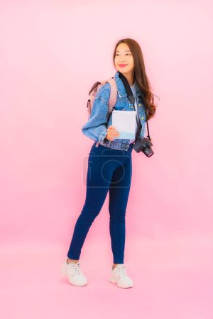 Foto de Retrato hermosa joven mujer asiática mochila o equipaje con cámara listo para viajar en vacaciones sobre fondo rosa - Imagen libre de derechos