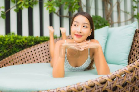 Foto de Retrato hermosa mujer asiática joven relajarse ocio alrededor de la piscina al aire libre en el complejo hotelero para vacaciones de viaje - Imagen libre de derechos