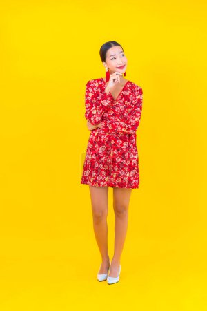 Portrait belle jeune femme asiatique sourire en action en chinois nouvelle année concept sur fond de couleur