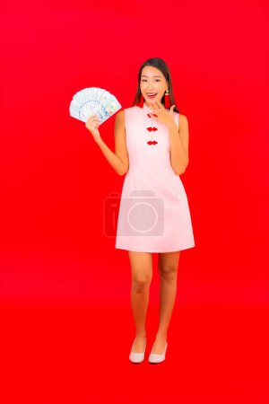 Photo for Portrait beautiful young asian woman with cash or money on red isolated background - Royalty Free Image