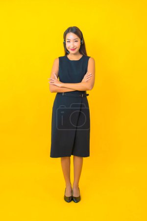 Photo for Portrait beautiful young asian business woman with headset call center customer care on yellow background - Royalty Free Image