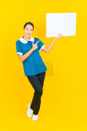 Photo for Portrait beautiful young asian woman maid and housekeeping smile with action on yellow color background - Royalty Free Image