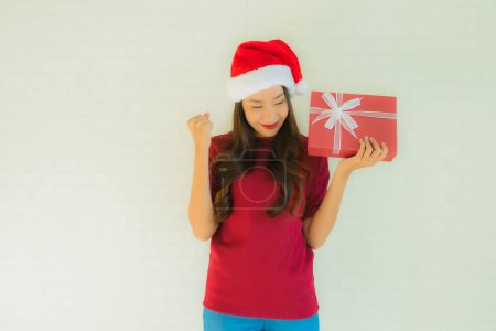 Téléchargez les photos : Portrait belles jeunes femmes asiatiques portent un chapeau de Père Noël dans le festival de Noël avec boîte cadeau pour la célébration - en image libre de droit