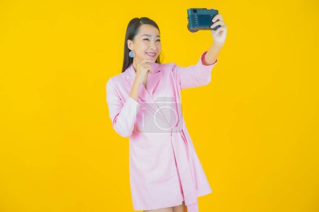 Foto de Retrato hermosa joven asiático mujer uso cámara en color fondo - Imagen libre de derechos
