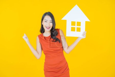 Photo for Portrait beautiful young asian woman with house or home paper sign on color background - Royalty Free Image