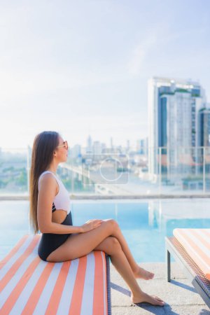 Téléchargez les photos : Portrait belle jeune femme asiatique se détendre loisirs autour de la piscine en vacances Voyage - en image libre de droit