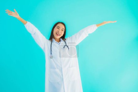 Téléchargez les photos : Portrait belle jeune asiatique médecin femme avec stéthoscope pour une utilisation en clinique ou à l'hôpital sur fond bleu isolé - en image libre de droit