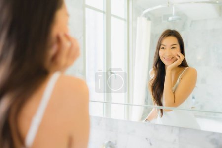Photo for Portrait beautiful young asian woman check up and make up her face on mirror in bathroom interior - Royalty Free Image