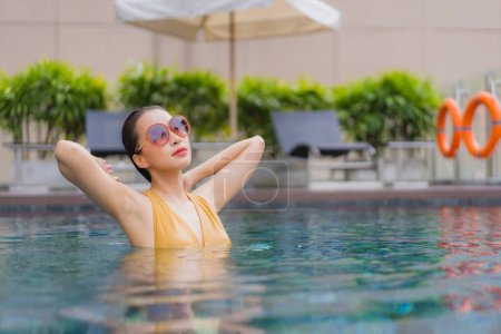 Téléchargez les photos : Portrait belle jeune femme asiatique détendre loisirs autour de la piscine dans la station hôtelière - en image libre de droit