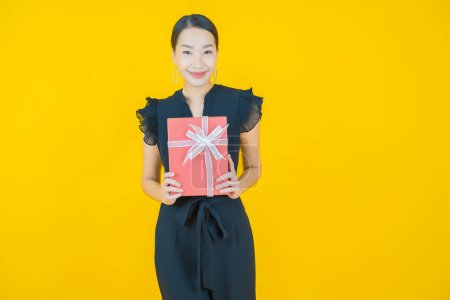 Photo for Portrait beautiful young asian woman smile with red gift box on color background - Royalty Free Image