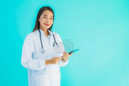Photo for Portrait beautiful young asian doctor woman with stethoscope and smart tablet for use in hospital and clinic on blue isolated background - Royalty Free Image