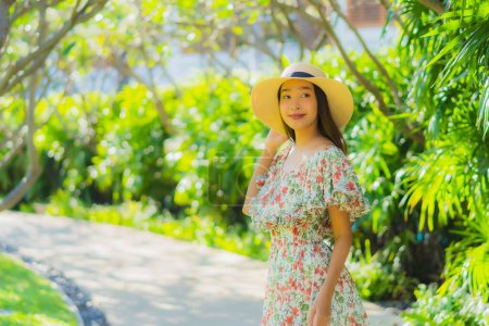 Foto de Retrato hermosa joven asiática mujer caminando con feliz disfrutar alrededor de jardín al aire libre vista - Imagen libre de derechos