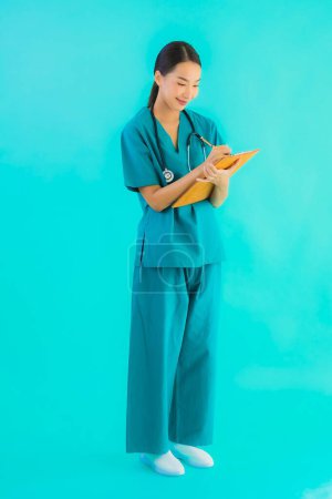 Photo for Portrait beautiful young asian doctor woman with empty paper board for copy space on blue isolated background - Healthcare in hospital and clinic concept - Royalty Free Image