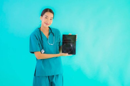 Foto de Retrato hermosa joven asiático médico mujer uso inteligente tableta dispositivo en azul aislado fondo - Imagen libre de derechos
