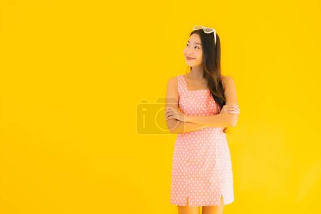 Téléchargez les photos : Portrait belle jeune femme asiatique sourire heureux sur fond jaune isolé - en image libre de droit