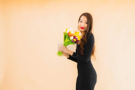 Téléchargez les photos : Portrait belle jeune femme asiatique avec fleur de couleur sur fond isolé couleur - en image libre de droit