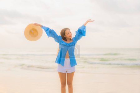 Foto de Retrato hermosa joven asiática mujer relajarse ocio sonrisa alrededor de playa mar océano al atardecer tiempo - Imagen libre de derechos
