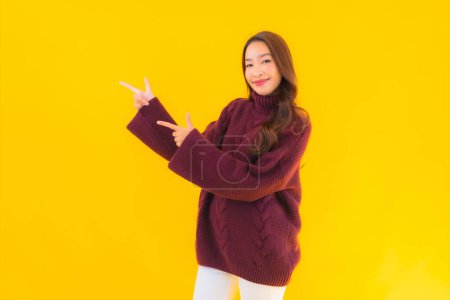 Téléchargez les photos : Portrait belle jeune femme asiatique sourire heureux dans une autre action sur fond jaune isolé - en image libre de droit
