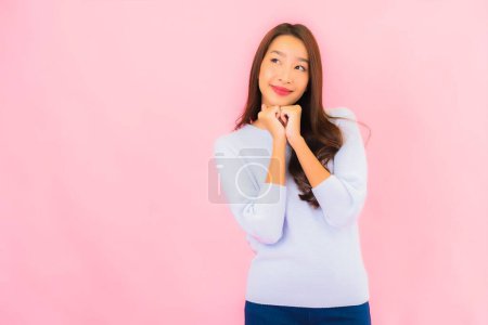 Foto de Retrato hermosa joven asiática mujer sonrisa con acción en rosa aislado fondo - Imagen libre de derechos