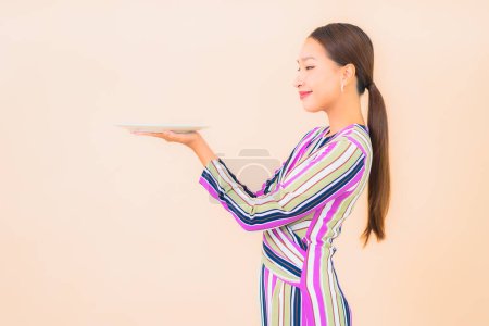 Foto de Retrato hermosa joven asiática mujer con plato de comida en color de fondo - Imagen libre de derechos