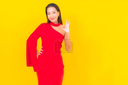 Photo for Portrait beautiful young asian woman smile with action on yellow isolated background - Royalty Free Image