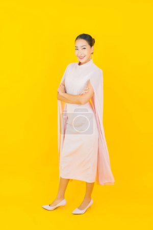 Photo for Portrait beautiful young asian woman smile with many action on yellow background - Royalty Free Image