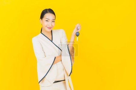 Photo for Portrait beautiful young business asian woman with car key on yellow background - Royalty Free Image