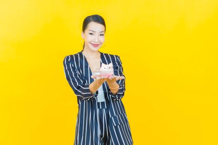 Photo for Portrait beautiful young asian woman with piggy bank on color background - Royalty Free Image